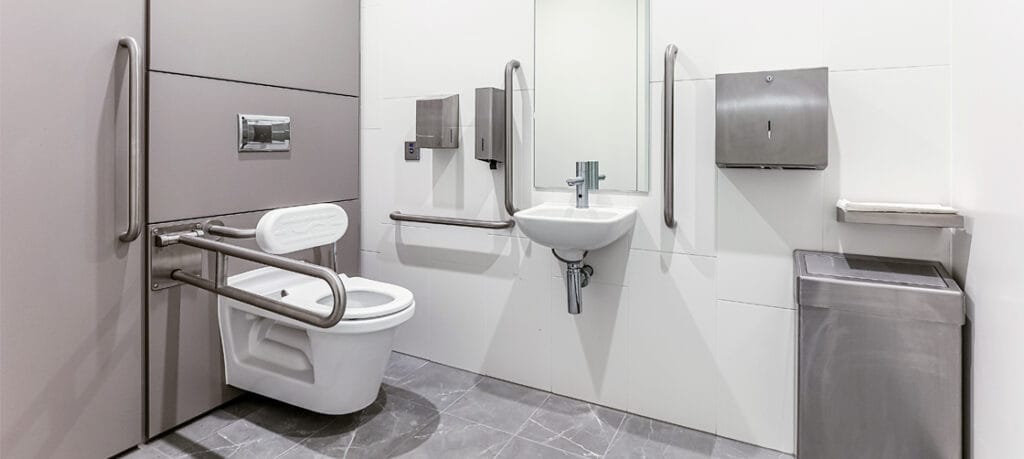 Enlarged unisex accessible toilet with a corner WC