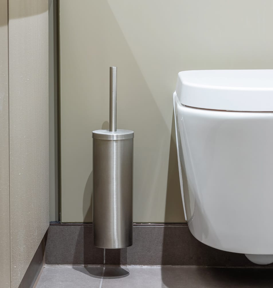 Toilet brush sets in a washroom cubicle