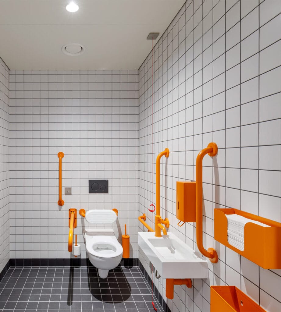 Doc M commercial washroom design with orange finished fittings