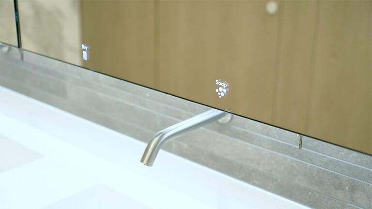 Close-up of a SMART touch-free tap and sop dispenser panel of a behind mirror system