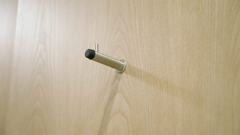 Coat hook and door stop in brushed stainless steel finish