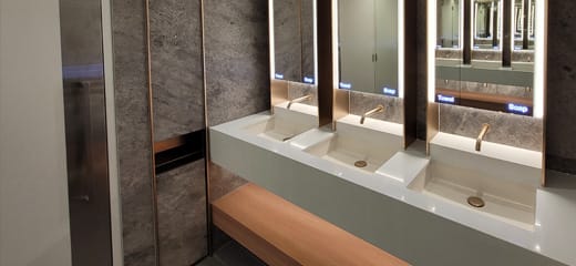 Sustainably coated sensor taps, waste bin, and basin waste trap in gold colour