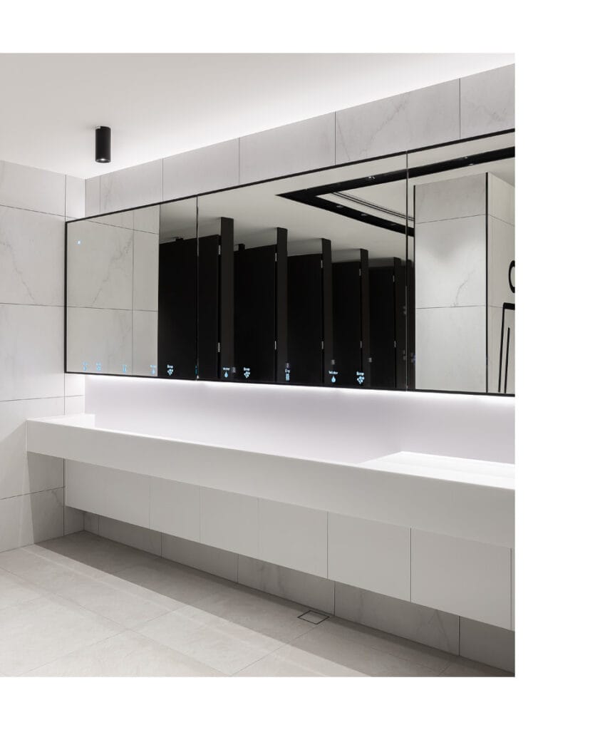 Behind mirror system fittings signage symbols clearly seen from the washroom entrance