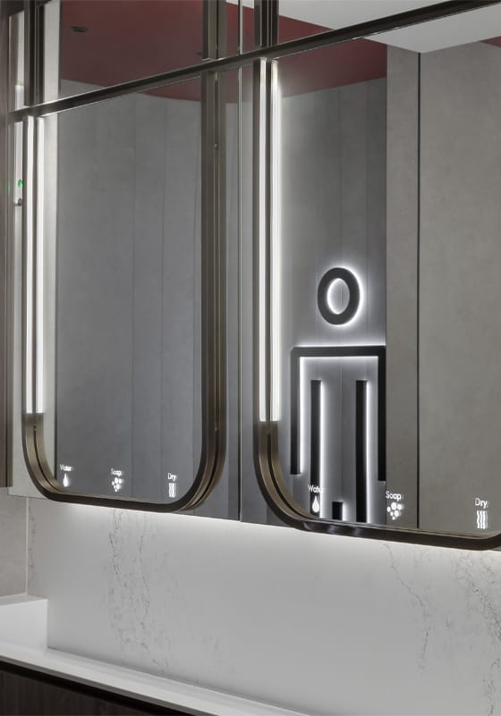 Well-lit male washroom signage symbol reflected on an Alavo mirror system