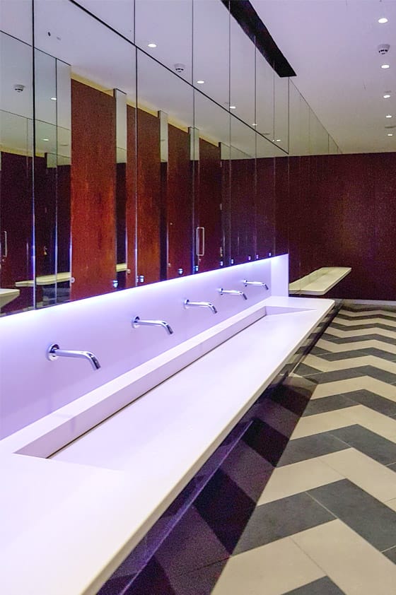Commercial washroom vanity designed with a set-down area at the left end