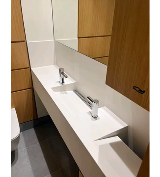 Superloo washroom with tap and soap dispenser positioned on opposite sides of washbasin