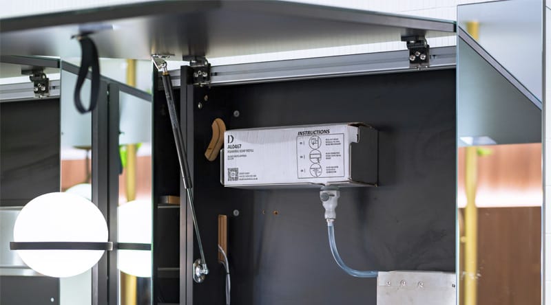 Foam soap cartridge installed behind a mirror for Alavo soap dispenser