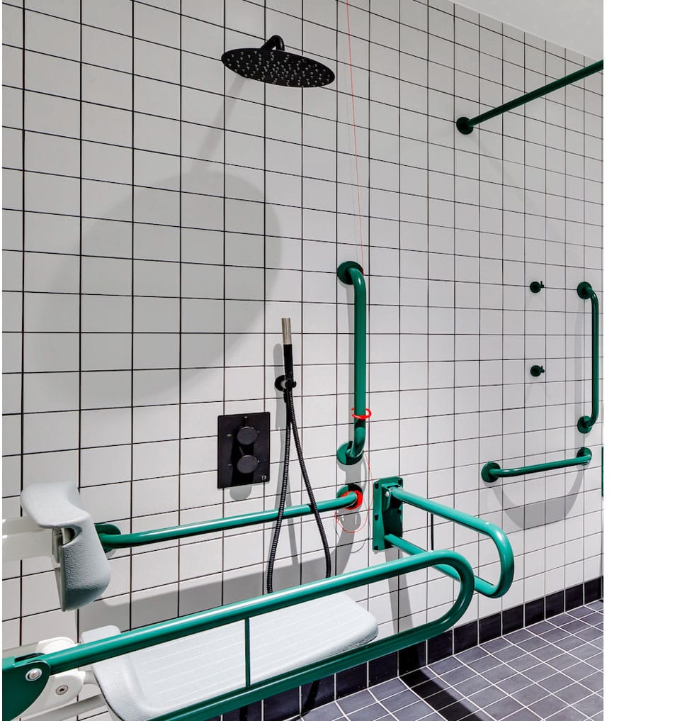 Compliant Doc M shower room with dark green and black special finish on washroom fittings