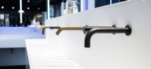 Row of wall mounted taps and soap dispensers in different styles and special coatings