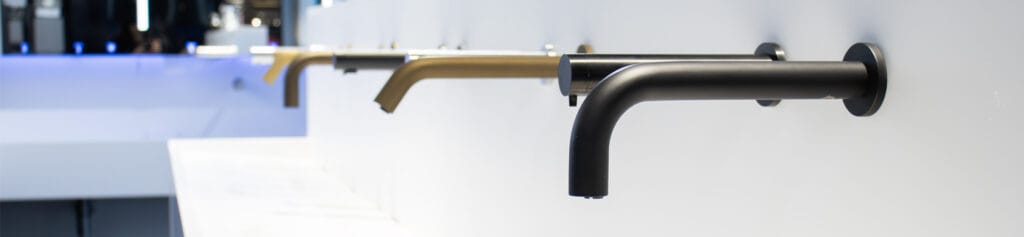 A line of wall mounted taps and soap dispensers