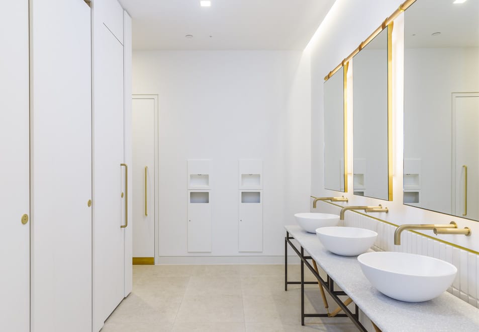 White and gold commercial washroom developed with a sustainable multifeed soap system